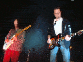 Photo de 2 guitaristes en train de jouer sur scène